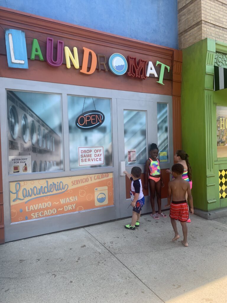 Taking a picture in front of Sesame Place Laundromat 